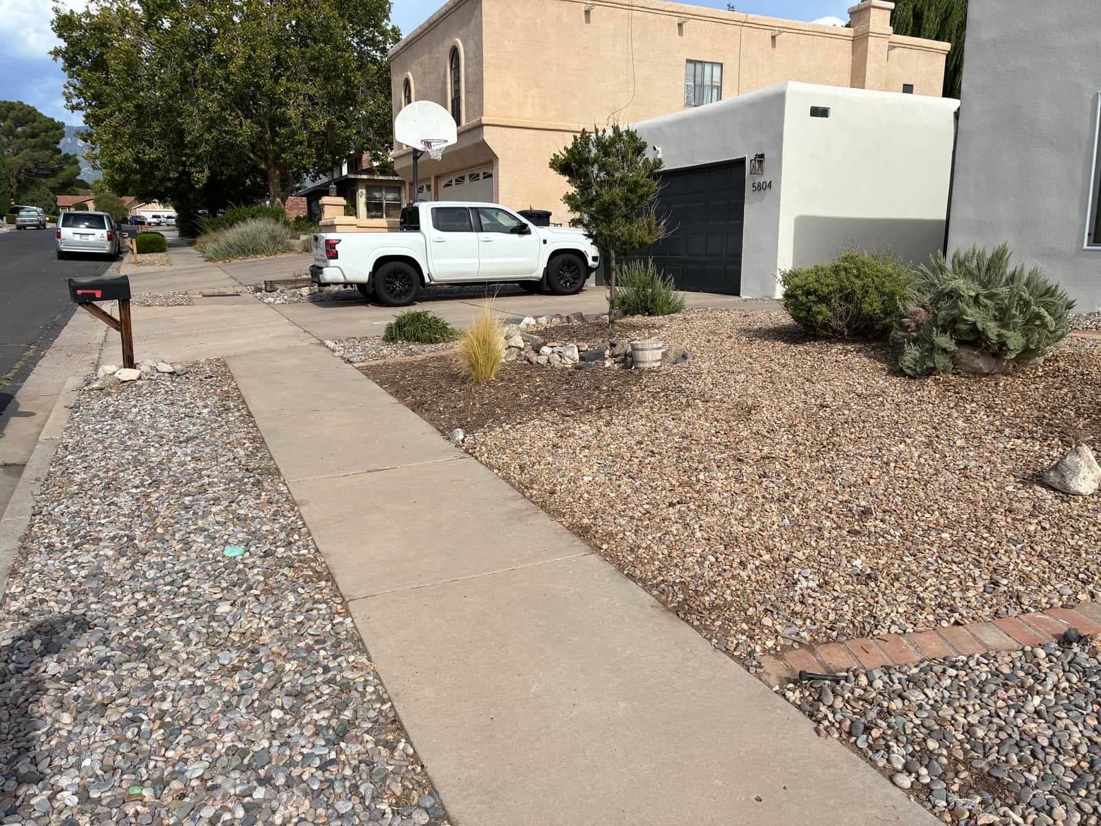 The same gravel bed cleared and reset with fresh rock and brick edging, Albuquerque