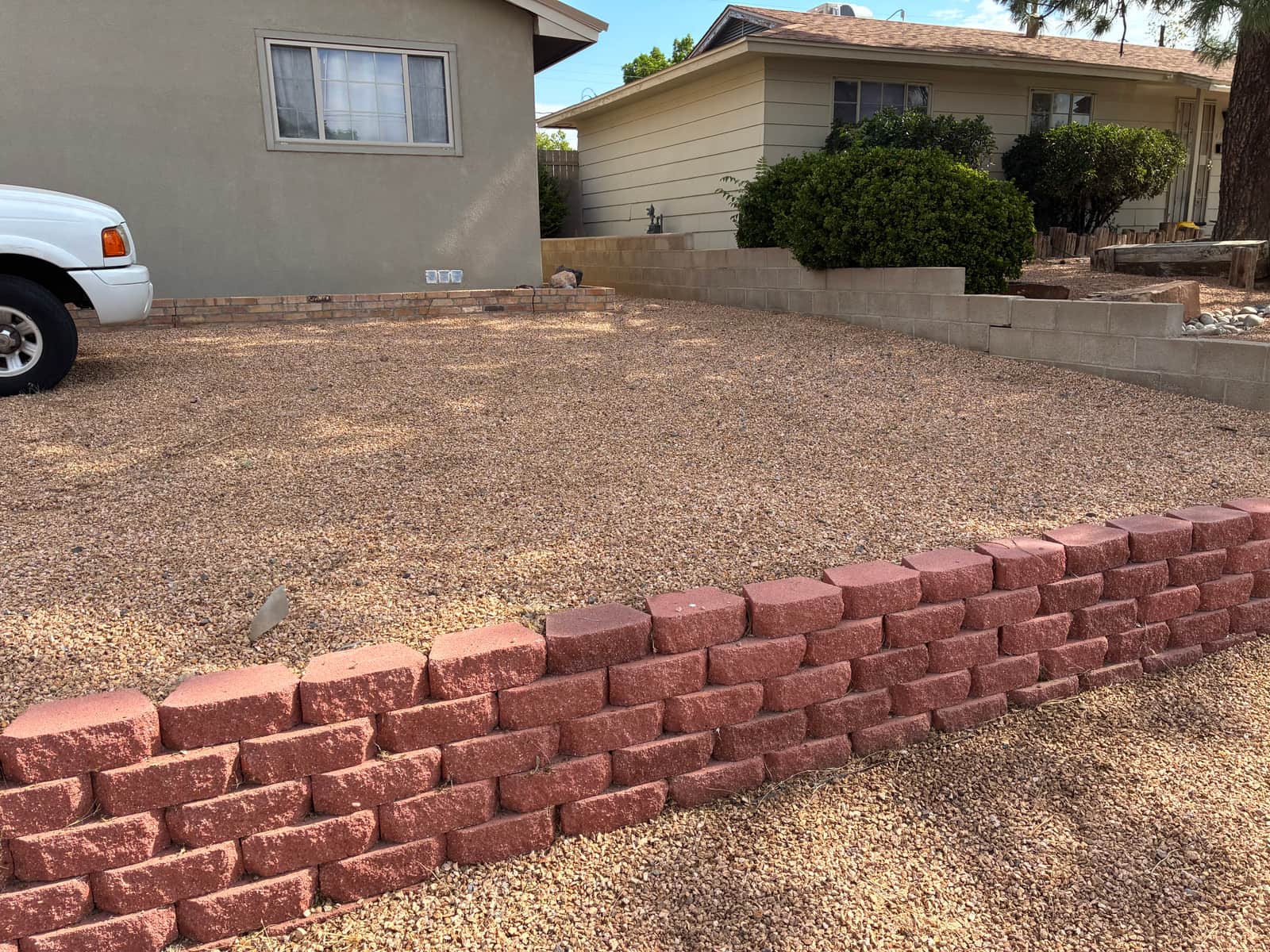 Same retaining wall in Albuquerque photographed from the yard side, bordering a gravel bed