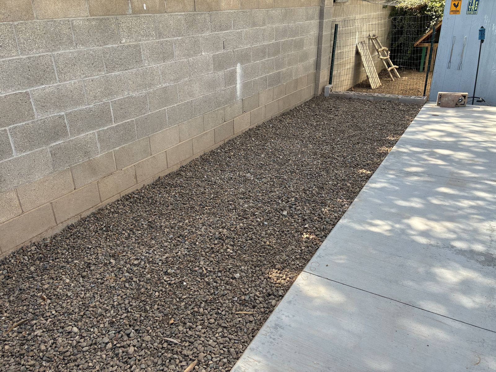 Gravel installed along a block wall beside new concrete